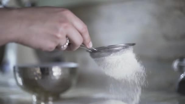 Mulher peneirando farinha através de uma peneira — Vídeo de Stock