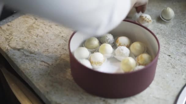 Femme mettant des bonbons faits maison dans une boîte ronde — Video