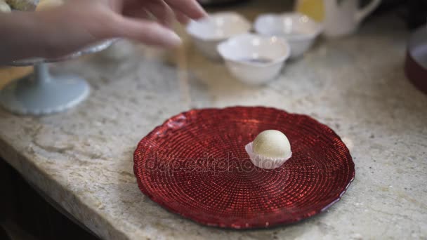 Женщина кладет домашние конфеты на тарелку — стоковое видео