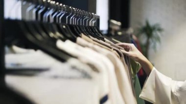 Genç kadın s el giysiler bir dükkanda seçmek