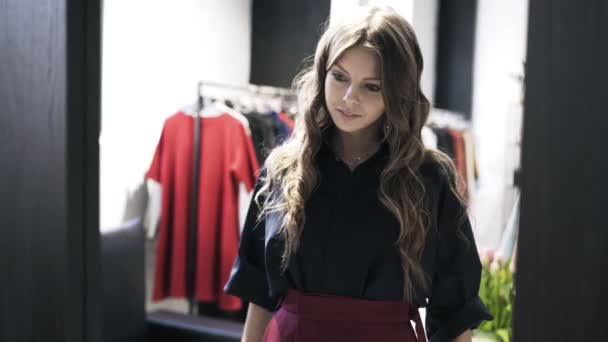 Femme heureuse regardant dans le miroir de magasin dans de nouveaux vêtements — Video