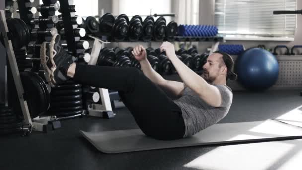 Musculoso hombre haciendo sit ups en un gimnasio — Vídeos de Stock