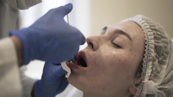 Косметик делает укол во рту — стоковое видео