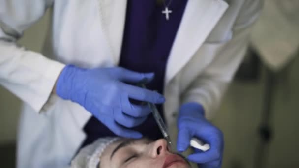 Inclinación hacia abajo de cosmético haciendo inyección de labios — Vídeos de Stock