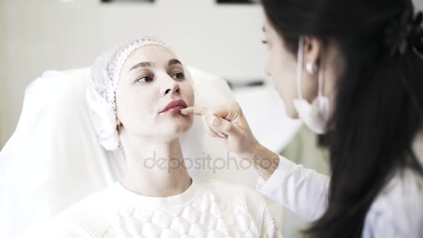 Kosmetyczka, dotykając kobieta usta s po strzałach — Wideo stockowe