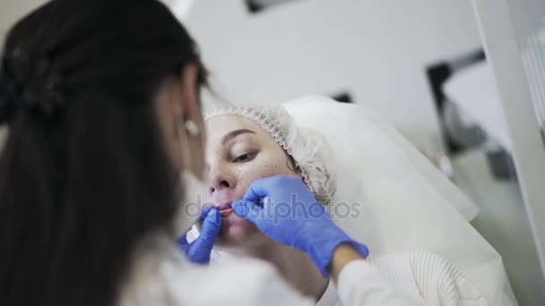 Cosmetician checking woman s lip after injection — Stock Video