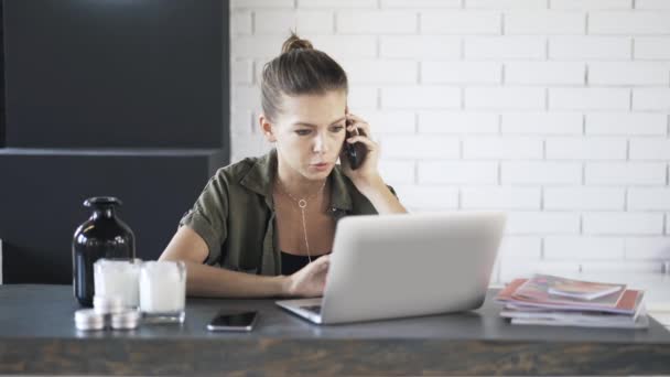 Jonge zakenvrouw is praten over een telefoon in kantoor — Stockvideo