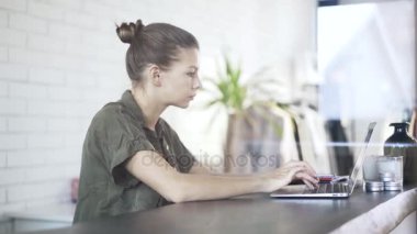 Yeşil gömlekli laptop yazarak genç kadın
