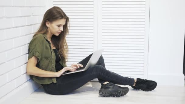 床の上のノート パソコンで入力する若い女性 — ストック動画