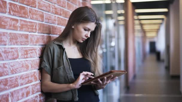 Ung kvinna med en tablett i office korridor — Stockvideo