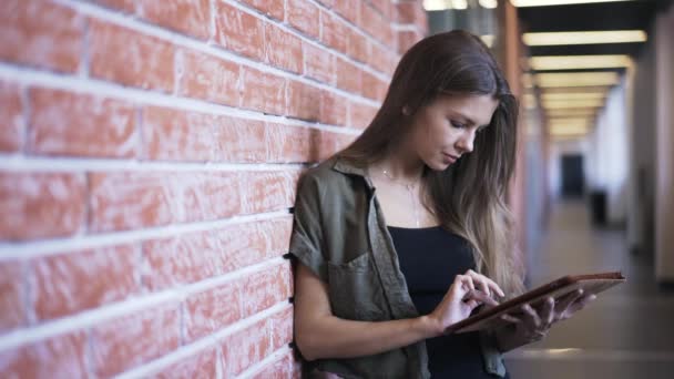 Mulher jovem web surf com tablet no corredor do escritório — Vídeo de Stock