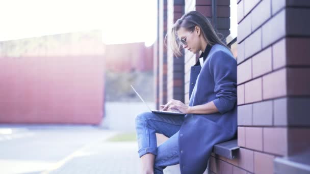 Vrouw op de vensterbank met laptop buiten — Stockvideo