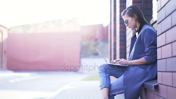 Donna sul davanzale della finestra con il computer portatile fuori, pan shot — Video Stock