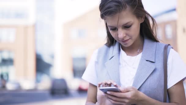 Mujer joven con smartphone en la calle — Vídeos de Stock