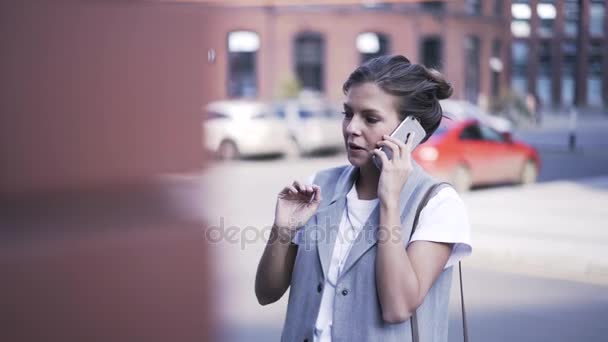 Junge Frau, die auf der Straße mit dem Smartphone spricht, aus nächster Nähe — Stockvideo