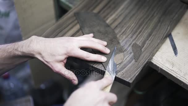 Сапожник режет кожу ножом — стоковое видео