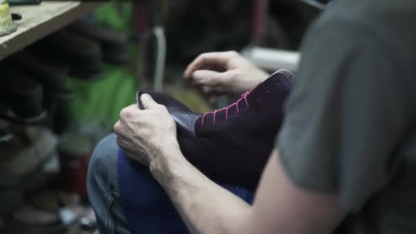Schuhmacher überprüft Schuh, bevor er an die Sohle nagelt — Stockvideo