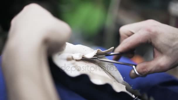 Close up van schoenmaker snijden leder met een schaar — Stockvideo