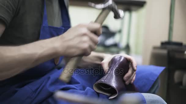 Vista laterale di calzolaio martellante stivali di una donna viola — Video Stock