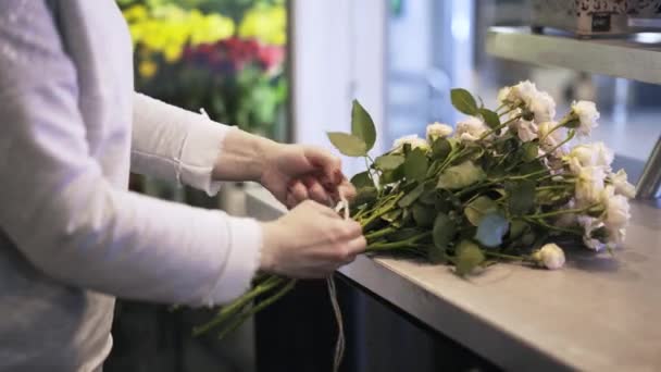 Kvinna florist gängning ett gäng vita rosor — Stockvideo