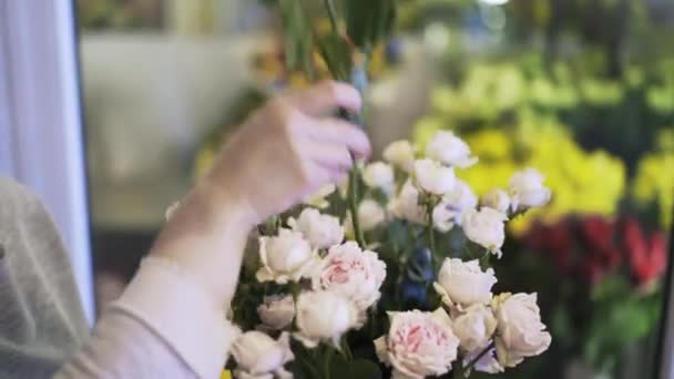 Vista laterale della donna fiorista mani mettendo rose in una scatola conica — Video Stock