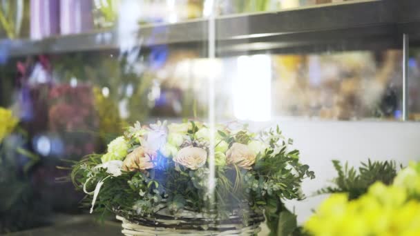 Woman florist arranging flowers in shop window — Stock Video