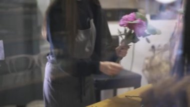 Birkaç pembe çiçekler ve dalları yapma kadın çiçekçi