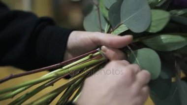 Onun dükkanında bir çiçek buketi bağlayan kadın s el yakın çekim