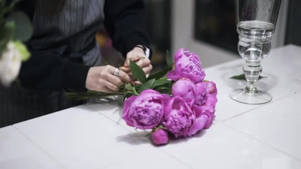 Primer plano del asistente de floristería atando ramo de flores rosadas — Vídeos de Stock