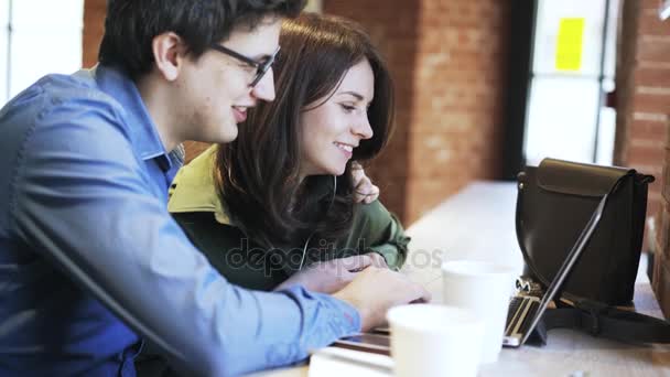 Pareja joven web surf en una cafetería vista lateral — Vídeos de Stock