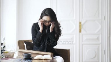 Güzel Asyalı kadın evde kitap okurken gözlük