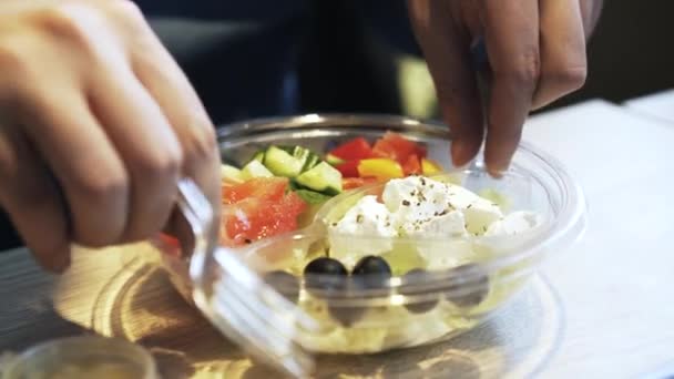 Mann isst griechischen Salat in einem Café — Stockvideo