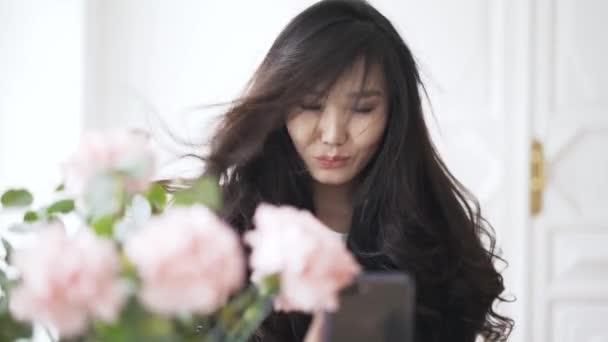 Young Asian woman is taking a selfie in the wind at home — Stock Video