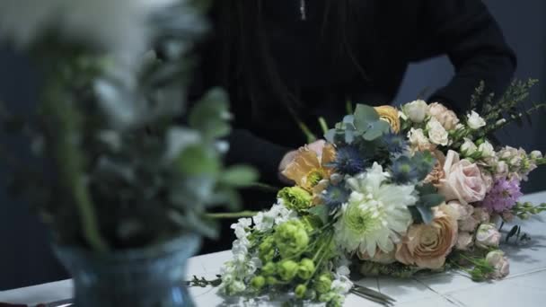 Plan panoramique d'un fleuriste attachant un bouquet de fleurs sur un comptoir — Video