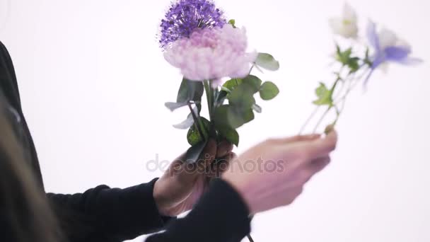 Close up de uma florista mulher organizando um monte de flores roxas, brancas e rosa — Vídeo de Stock