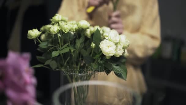 Cierre de floristería empleado de corte de tallo de flores con un cuchillo — Vídeos de Stock