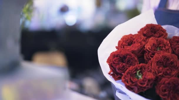 Mulher florista segurando um belo buquê de rosas vermelhas escuras — Vídeo de Stock