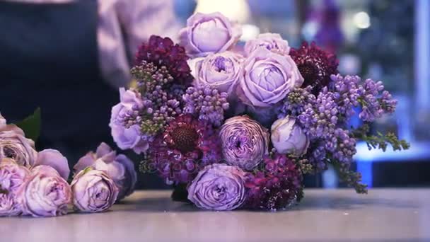 Primer plano de una florista mujer haciendo un ramo púrpura, toma de la cacerola — Vídeos de Stock