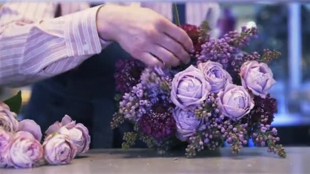 Nahaufnahme einer Blumenhändlerin, die einen lila Blumenstrauß macht, Pan Shot — Stockvideo