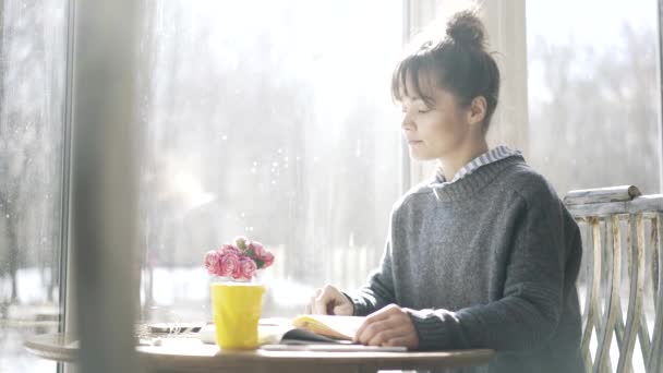 Joven estudiante universitaria está estudiando en un café y cogiendo su teléfono — Vídeos de Stock