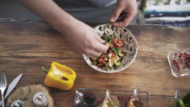 Bovenaanzicht van een chef-kok mengen een plantaardige salade in een bord — Stockvideo