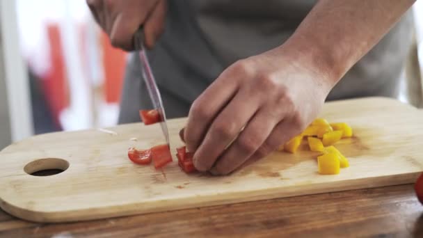 Chef rebanando un pimiento amarillo y rojo y poniéndolos en un tazón — Vídeo de stock