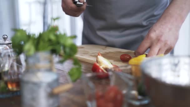 Kuchař, krájení na plátky cherry rajčátka a jejich uvedení v misce — Stock video