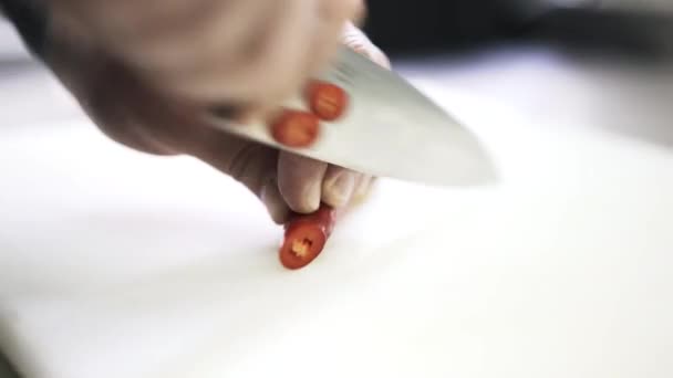 Close up de um cozinheiro cortando uma pimenta em um restaurante — Vídeo de Stock