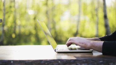 Laptop klavye bir parkta, yazarak adam