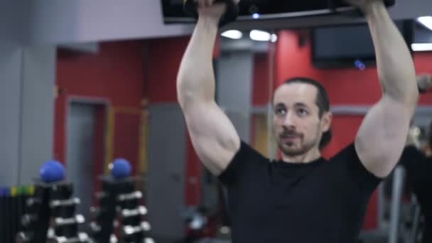 Retrato de hombre de negro haciendo flexiones con anillos gimnásticos — Vídeos de Stock