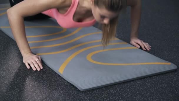 Вид спереди женщины, делающей отжимания в спортзале — стоковое видео
