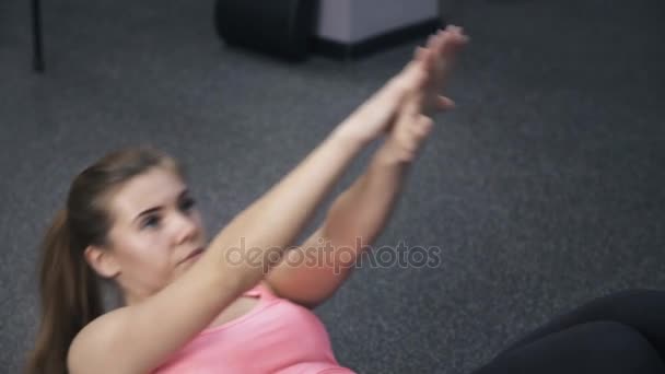 Κοντινό πλάνο του κοριτσιού σε ροζ κάνει situps σε ένα γυμναστήριο — Αρχείο Βίντεο