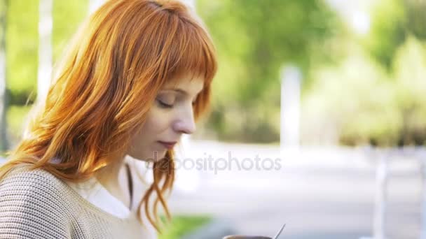Vista lateral de una mujer pelirroja tomando té afuera — Vídeo de stock