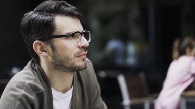 Konuşan bir kafe bir genç hipster adam yan görünüm gözlük